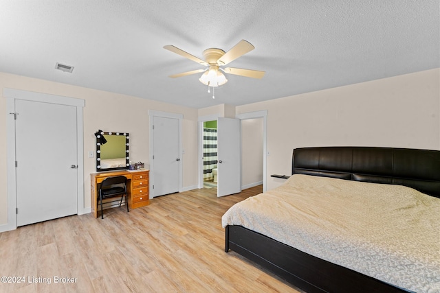 bedroom featuring ceiling fan, a textured ceiling, and light hardwood / wood-style flooring