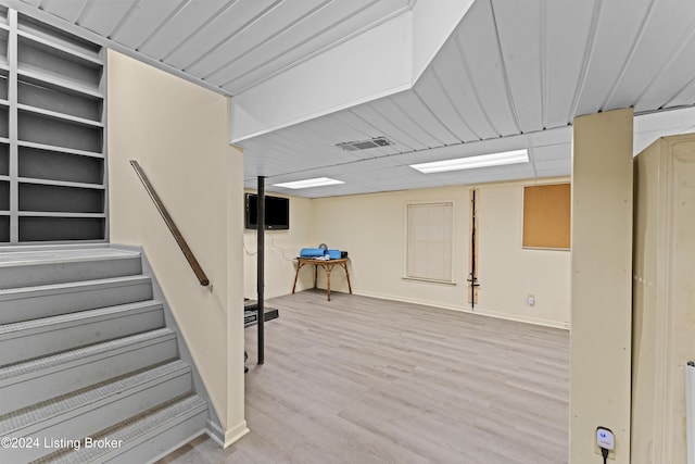 basement with light hardwood / wood-style flooring