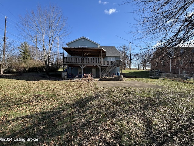 rear view of property featuring a patio area, a yard, and a wooden deck