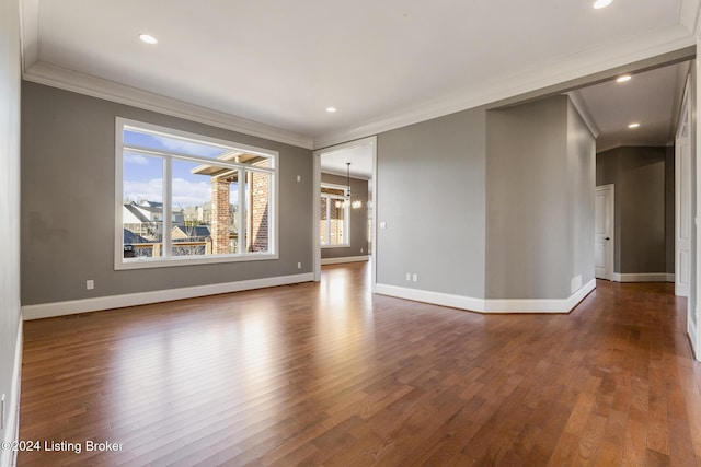 unfurnished room with dark hardwood / wood-style floors, an inviting chandelier, and crown molding