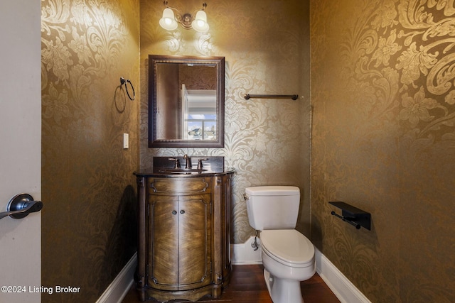 bathroom with hardwood / wood-style floors, vanity, and toilet