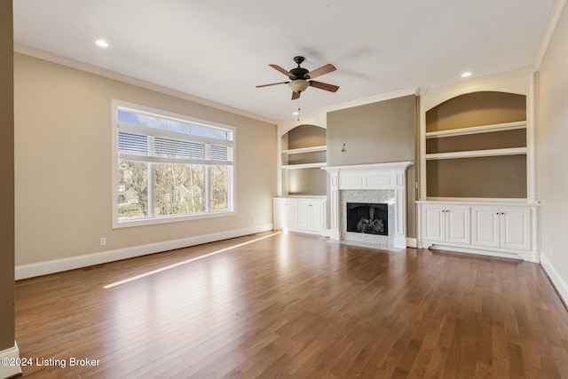 unfurnished living room featuring crown molding, hardwood / wood-style floors, and built in features