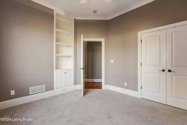 unfurnished bedroom featuring carpet, a closet, ceiling fan, and ornamental molding