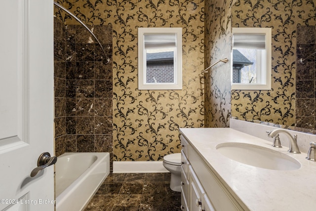 full bathroom featuring vanity, tiled shower / bath combo, and toilet