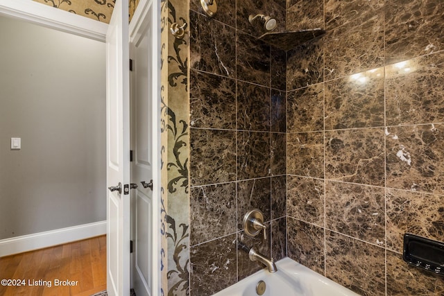 bathroom featuring tiled shower / bath combo and hardwood / wood-style flooring