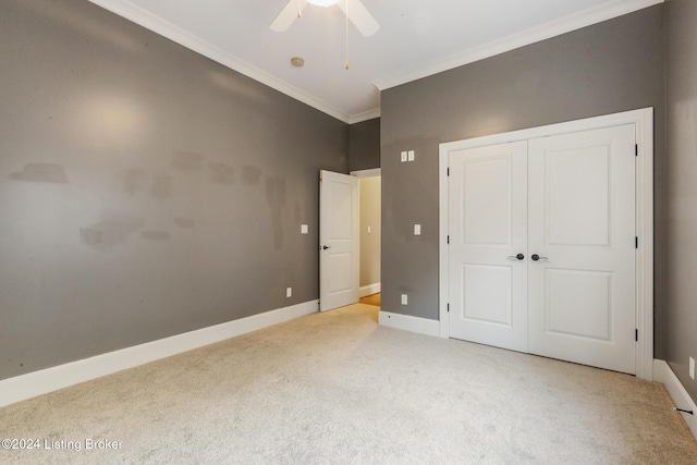 unfurnished bedroom with ceiling fan, a closet, light carpet, and ornamental molding