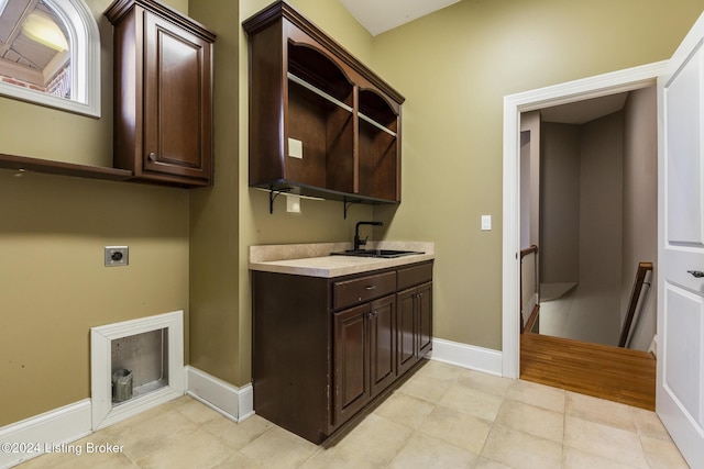 laundry area featuring electric dryer hookup, sink, and cabinets