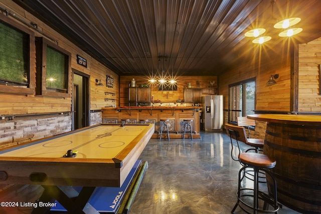 recreation room with wood ceiling and wood walls