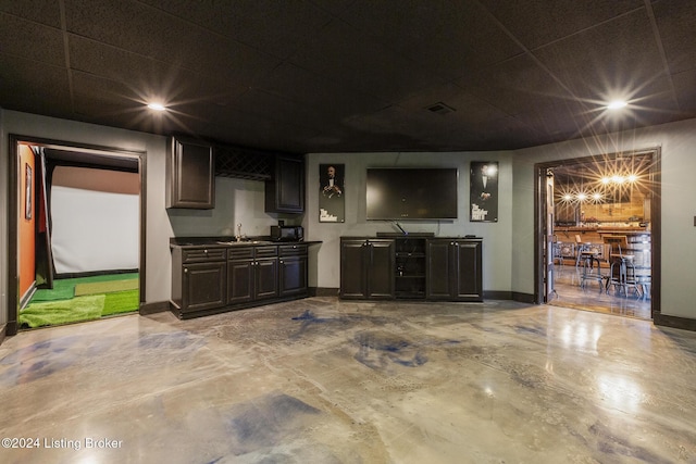 interior space featuring golf simulator, sink, and concrete flooring