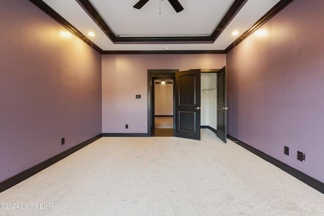 unfurnished bedroom with a tray ceiling and light carpet