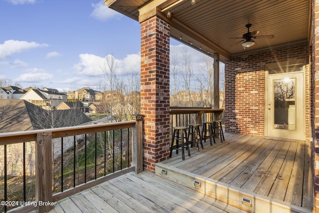 wooden terrace with ceiling fan and exterior bar