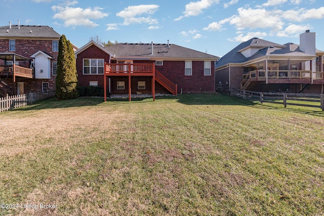 rear view of house featuring a yard and a wooden deck