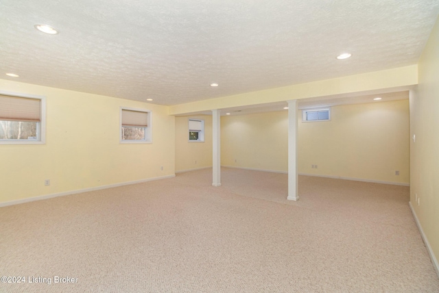 basement with light colored carpet and a textured ceiling