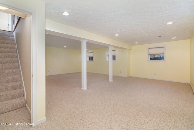 basement with light carpet and a textured ceiling