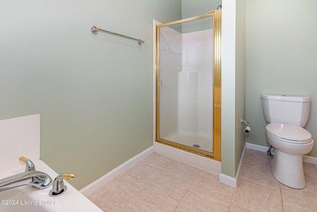 bathroom with tile patterned floors, toilet, and a shower with door