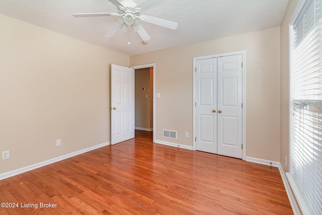 unfurnished bedroom featuring ceiling fan, light wood-type flooring, and a closet