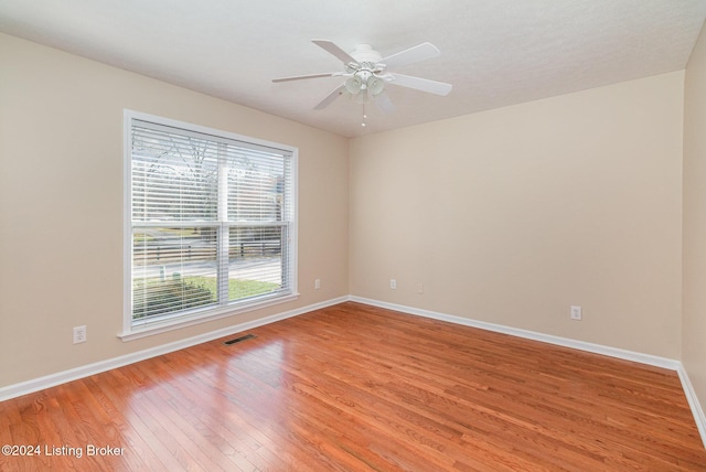 empty room with ceiling fan and hardwood / wood-style floors