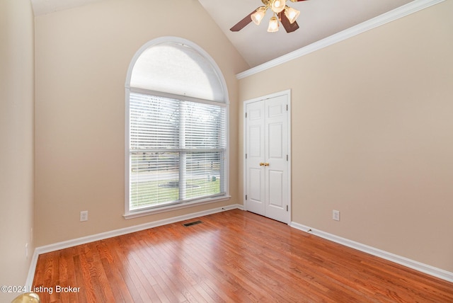 spare room with light hardwood / wood-style floors, a wealth of natural light, lofted ceiling, and ceiling fan