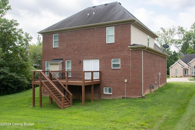 rear view of house featuring a wooden deck and a yard