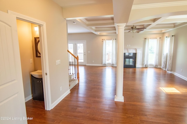 unfurnished living room featuring a wealth of natural light, coffered ceiling, ceiling fan, and dark hardwood / wood-style floors