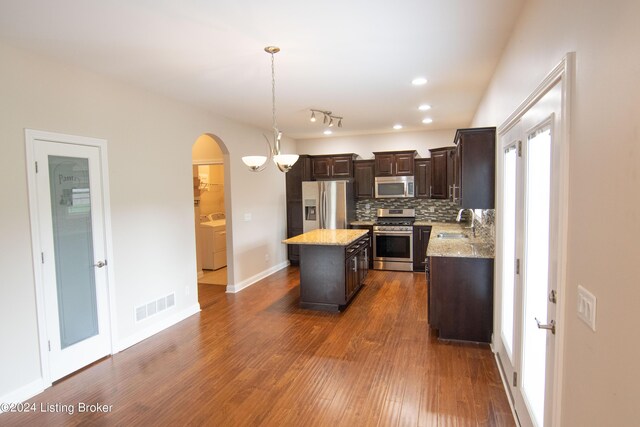 kitchen featuring pendant lighting, a center island, dark wood-type flooring, sink, and stainless steel appliances