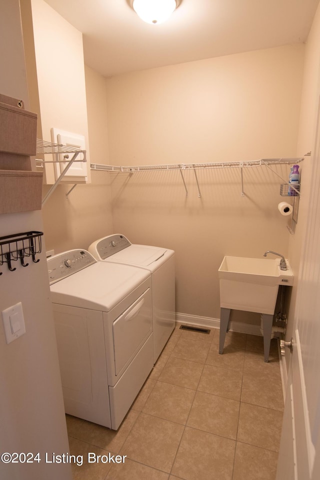 laundry area with separate washer and dryer, sink, and light tile patterned flooring