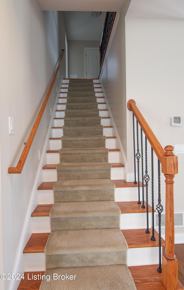 stairs featuring hardwood / wood-style floors