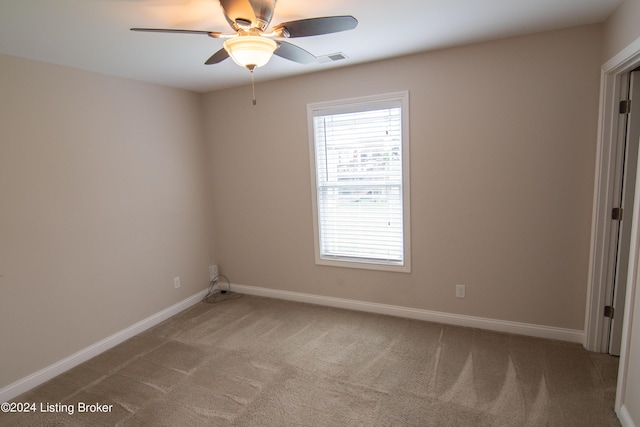 spare room with ceiling fan and carpet