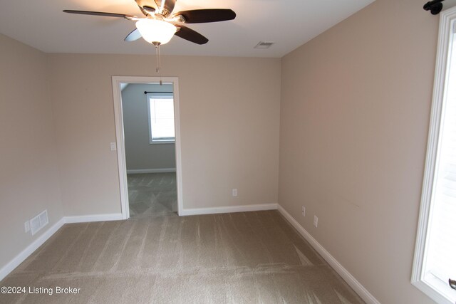 spare room with ceiling fan and carpet