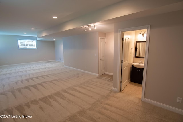 basement with sink and light carpet