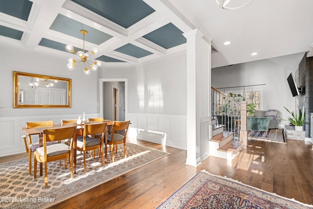 dining room with coffered ceiling, an inviting chandelier, light hardwood / wood-style flooring, and beam ceiling