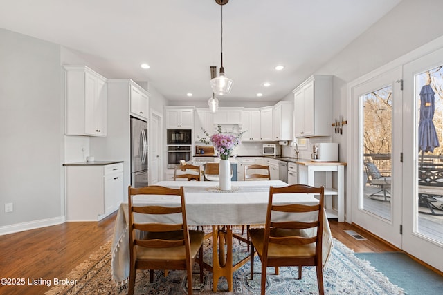 dining room with sink and wood-type flooring