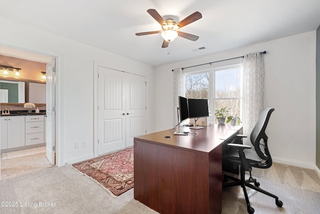 carpeted office space with ceiling fan