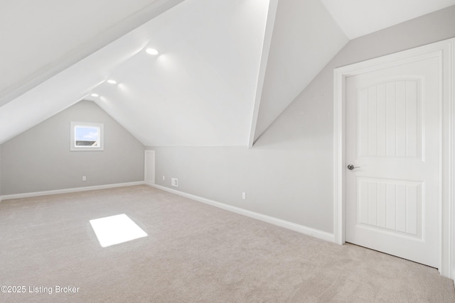 additional living space with light carpet and vaulted ceiling