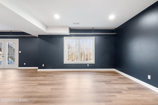 spare room featuring french doors and light wood-type flooring