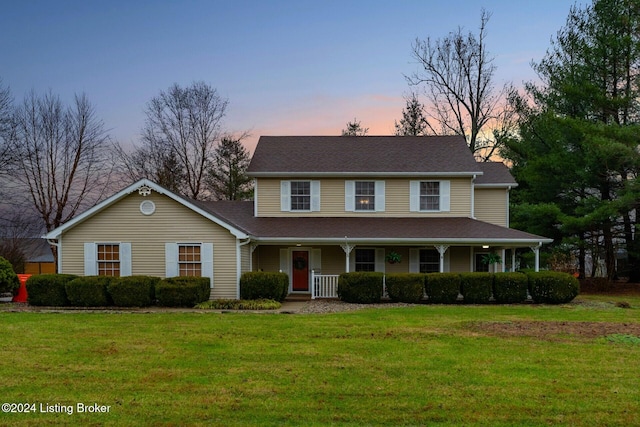 view of front of house with covered porch and a yard