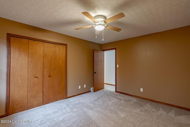 unfurnished bedroom featuring ceiling fan, carpet floors, a textured ceiling, and a closet