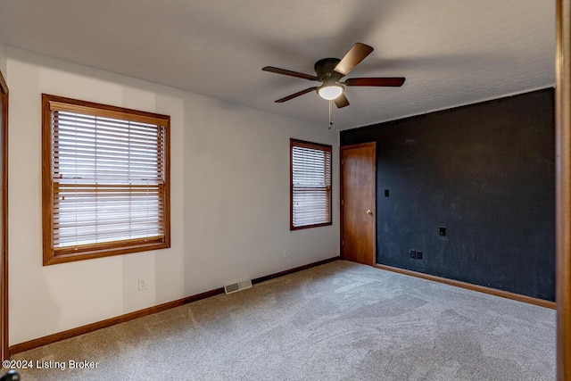 spare room featuring ceiling fan and carpet floors