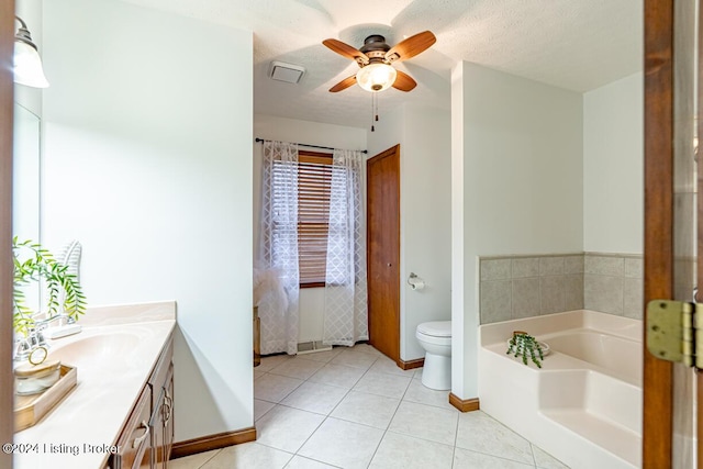 bathroom featuring a tub to relax in, vanity, toilet, tile patterned floors, and a textured ceiling