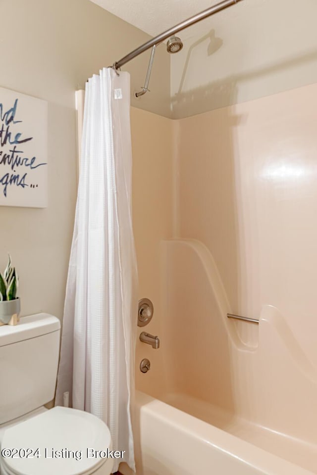 bathroom featuring shower / bath combo and toilet