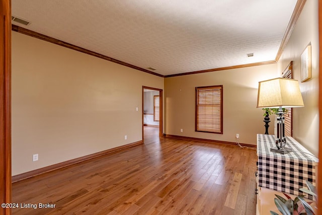 unfurnished living room with crown molding and light hardwood / wood-style flooring