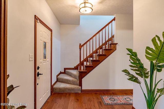 entrance foyer with wood-type flooring and a textured ceiling