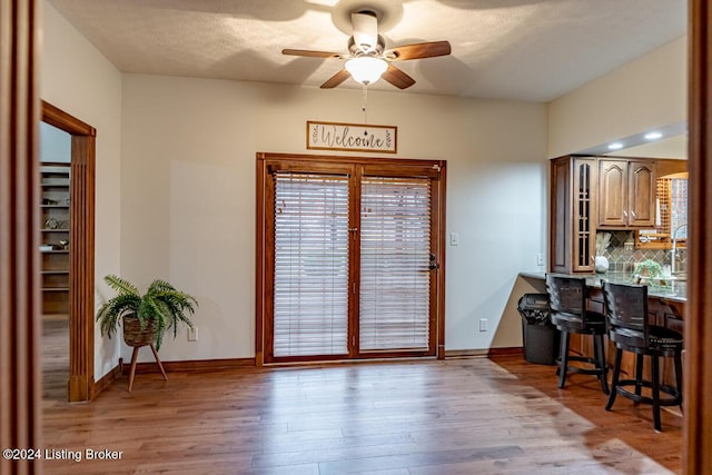 interior space featuring ceiling fan, a textured ceiling, and light wood-type flooring