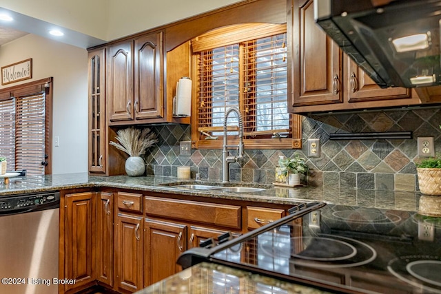 kitchen featuring extractor fan, sink, tasteful backsplash, dark stone countertops, and stainless steel dishwasher