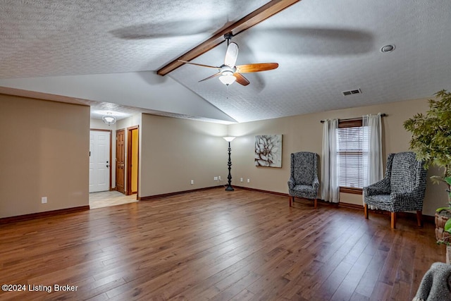 unfurnished room with vaulted ceiling with beams, hardwood / wood-style floors, and a textured ceiling