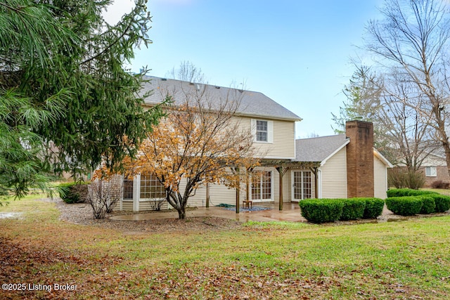 back of house featuring a lawn, a patio area, and a pergola