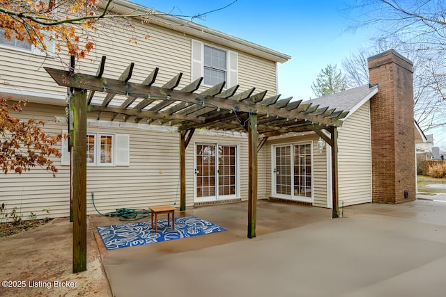 back of property with a pergola and a patio area