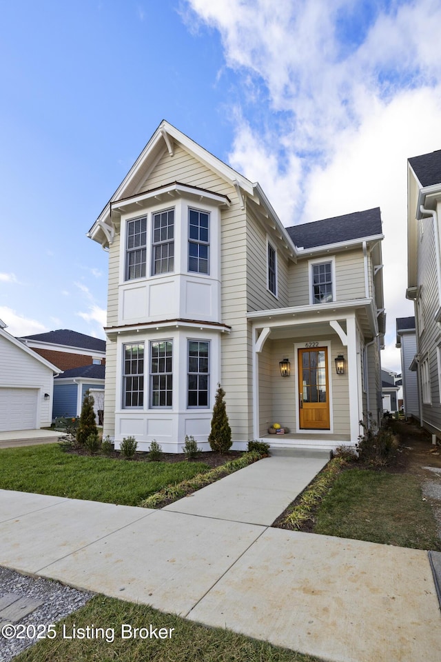 front facade featuring covered porch and a front lawn