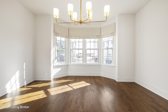 unfurnished room featuring dark hardwood / wood-style floors and an inviting chandelier