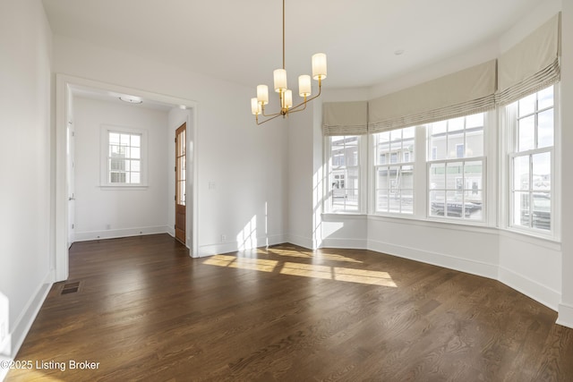 unfurnished dining area featuring dark wood-type flooring and a notable chandelier